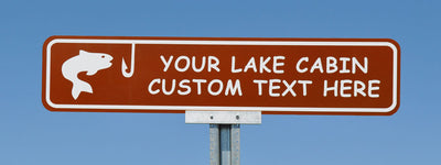 custom lake cabin sign with a brown background and white text that says 'your lake cabin custom text here' with an image of a fish and hook in white