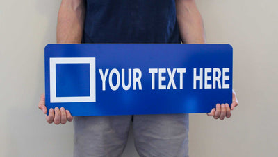 man holding a custom blue square ski sign with a blue background and white text that says 'your text here'