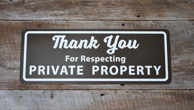 metal sign that says 'thank you for respecting private property' in white text with a brown background on a wooden background