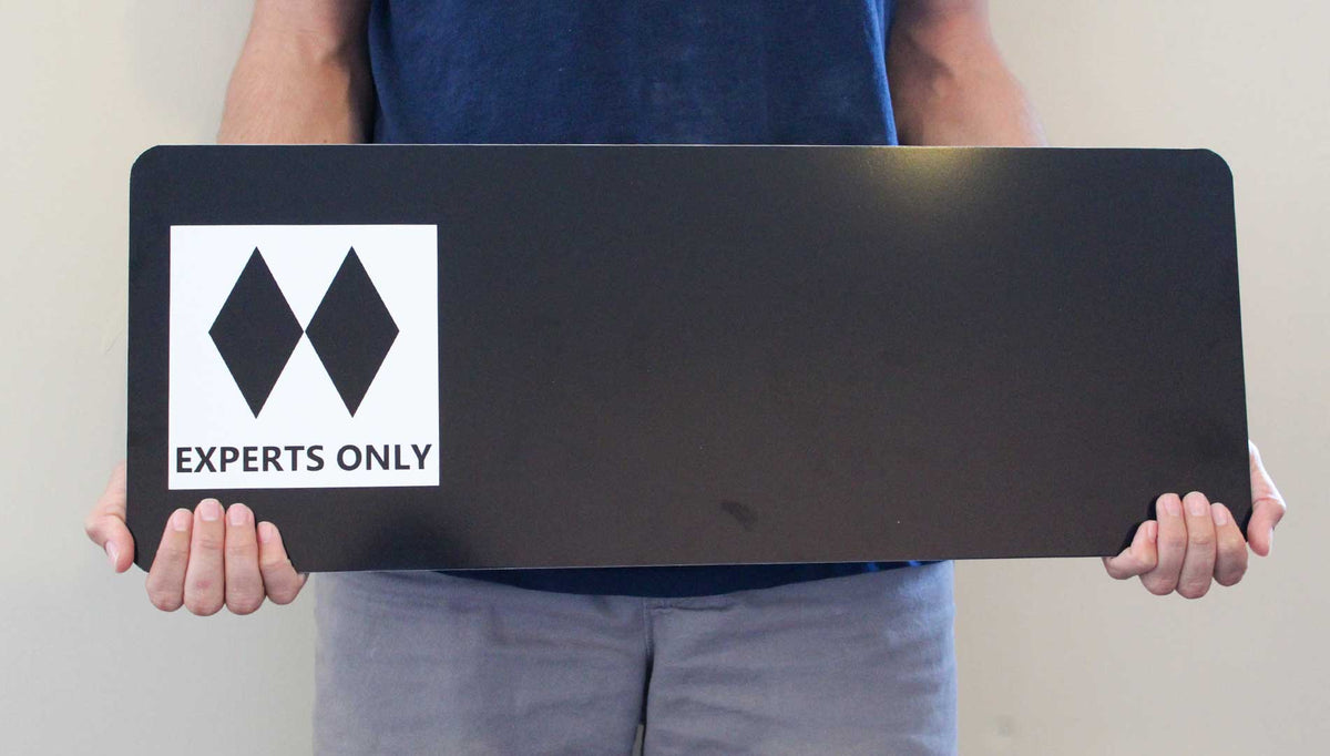 man holding a custom double black diamond ski run sign with a black background and spot for your custom text