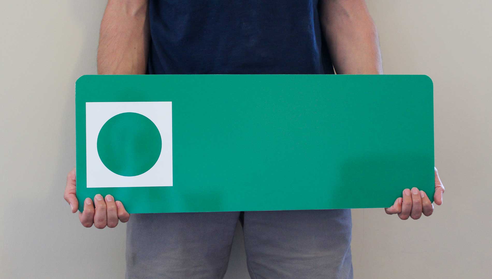 a man holding a custom metal green ski run sign with a green background with a spot for your custom text