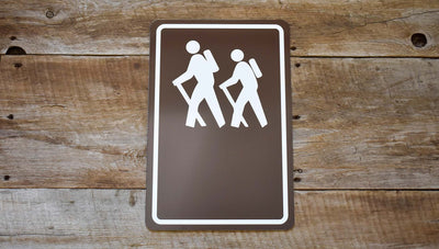 custom hiking trail sign with image of people hiking in white with a brown background