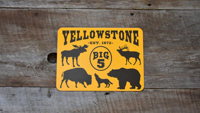 metal sign with a yellow background and black text that says 'Yellowstone Big 5' with black outlines of a moose, elk, bison, wolf, and grizzly bear