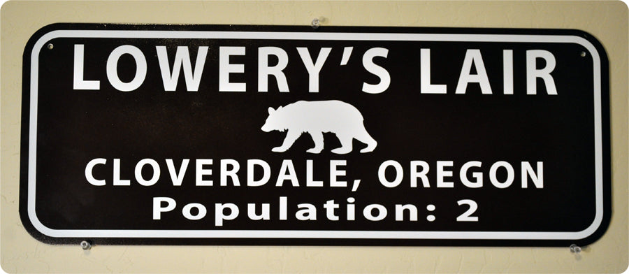metal sign with white text that says 'lowery's lair' on a brown background