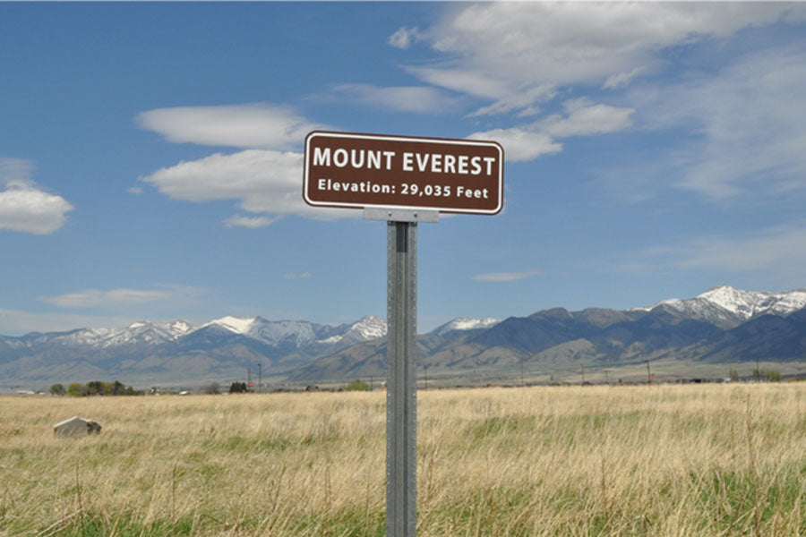 metal sign with a brown background and white text that says 'Mount Everest Elevation: 29,035 feet'