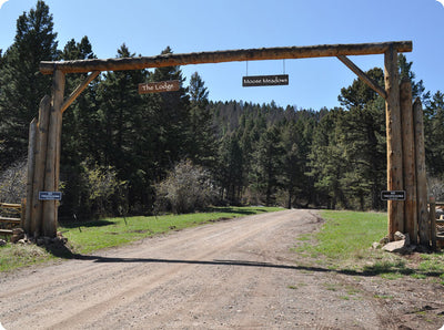 metal sign with white text saying 'no trespassing private property' with a brown background on a ranch entryway